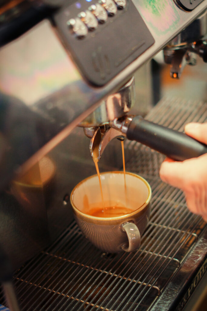 Barista pouring latte art at Fuel Coffee Shop.